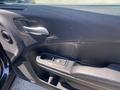 Interior door panel of a 2019 Dodge Charger featuring a black leather finish and controls for window operation