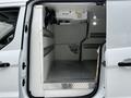 A 2019 Ford Transit Connect with an open side door revealing a spacious, empty cargo area featuring steel flooring and wall-mounted storage rails