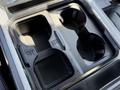 Cup holder section of a 2024 Ford F-550 Super Duty featuring two beverage compartments with button controls on the side