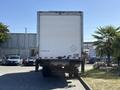 A 2015 Freightliner M2 106 truck parked with the rear side facing the viewer showcasing a plain white box trailer
