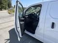 A 2019 Nissan NV200 with its driver's side door open revealing the interior featuring a steering wheel and driver's seat