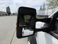 A side mirror of a 2008 Ford F-550 showing a clear reflection of the street and nearby vehicles