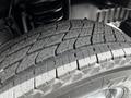 Close-up of a worn tire from a 2018 Ford Econoline showing distinct tread patterns and a rugged texture
