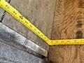 A measuring tape laid out on a wooden surface showing various measurements in inches and centimeters