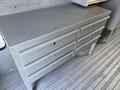 A gray metal tool cabinet with multiple drawers designed for storage in a workspace