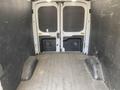 Interior of a 2022 Ford Transit van with open rear doors and a spacious cargo area featuring a flat floor and sidewall protection panels