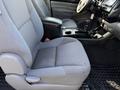Interior of a 2015 Toyota Tacoma featuring a gray cloth seat and a center console with cup holders and controls