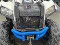 2017 Polaris Scrambler with a rugged design featuring large tires a black chassis and a blue front bumper with a winch attached