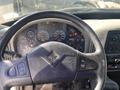 The interior dashboard of a 2014 International 7400 featuring a steering wheel with control buttons and an array of gauges including speedometer and tachometer