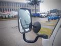 A 2003 Toyota Toyoace with a side mirror reflecting a rainy scene