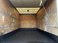 Interior of a 2015 Hino 195 box truck showing bare wooden walls and a rubber floor with metal tracks for securing cargo