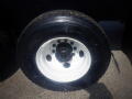 Close-up of a tire mounted on a white wheel featuring multiple circular holes designed for a 2016 International WorkStar 7500 truck