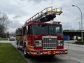 A red 2009 Spartan Gladiator fire truck with a ladder on top and the number E-1 displayed prominently on the front