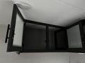 A 2022 Aspen Trail camper with a black cabinet featuring glass doors and a handle, positioned upside down for display purposes.