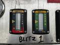 Two gauges labeled "WATER" and "FOAM" showing fluid levels with indicators in red and green on a metallic panel with the text "BLITZ 1" written below them