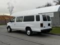 A white 2011 Ford Econoline van parked on the street with a smooth body and large rear windows