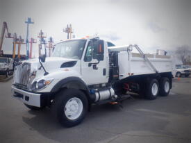 A 2016 International 7400 dump truck with a white exterior and a large open cargo bed in the back
