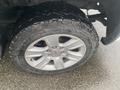 Close-up of a damaged tire on a 2015 GMC Sierra 1500 showcasing the silver alloy wheel and rugged tread pattern