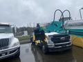 2024 AGT Industrial MH12R Mini Excavator with a bright teal and yellow design parked next to a large white truck