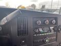 Interior dashboard controls of a 2016 Chevrolet Express featuring climate knobs audio system and various buttons