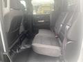 Interior view of a 2015 Chevrolet Silverado 3500HD showing the rear bench seat with gray upholstery and seatbelts