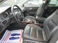 Interior view of a 2006 Audi A6 showcasing black leather front seats and a dashboard with various controls and gauges