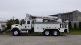 A white 2012 International 7400 truck equipped with a utility crane and tools mounted in the bed