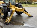 A yellow 2014 Caterpillar TL1055C telehandler with two extended hydraulic arms and a large tire in the foreground
