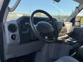 Interior of a 2019 Ford E-450 featuring a steering wheel dashboard controls and seating area