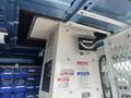A 2010 Ford Econoline van interior featuring a control panel with gauges and warning labels, including a temperature gauge and a ventilation fan system
