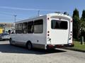 A white 2014 Chevrolet Express bus with large windows and rear lights parked in a lot