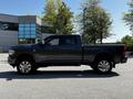 A 2022 RAM 3500 pickup truck in dark gray with chrome accents and large polished wheels parked on a smooth surface