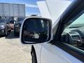 A 2011 Chevrolet Colorado with a focus on its side mirror reflecting nearby vehicles