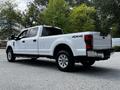 A 2020 Ford F-350 Super Duty truck in white with a spacious cab and 4x4 designation visible on the rear side