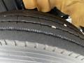 A close-up of the tire of a 2006 Hino 268 showing tread patterns and small debris embedded in the rubber surface