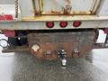 A rusty towing hitch attached to the rear of a 2011 Dodge Ram 5500 with visible brake lights and a worn metal surface