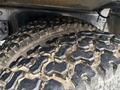 Close-up of a rugged tire with deep treads from a 2018 Kenworth T800 showing wear and dirt on its surface