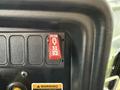 A red shutdown switch labeled "SHUT DOWN" on a black control panel with additional warning and operational labels
