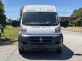 A 2016 RAM Promaster van facing forward with a white front and dark gray lower section featuring large side mirrors and a horizontal grille