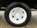 Close-up of a white wheel from a 2018 Hino 195 with a black tire featuring a prominent tread pattern and visible lug nuts