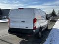 A 2018 Ford Transit van parked on a street with a snow-covered ground