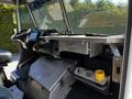 Interior of a 2009 Morgan Olson Workhorse featuring a steering wheel dashboard and metal storage compartments with a yellow cup on the floor