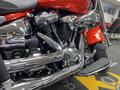 Close-up view of a 2024 Harley Davidson Fat Boy motorcycle showcasing its chrome engine components and exhaust pipes