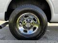 A close-up of a chrome alloy wheel with a Chevrolet logo and a Bridgestone tire on a 2015 Chevrolet Express