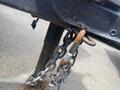 A close-up of a rusted latch and chain attached to the hitch of a 2020 Stealth Enterprises Trailer