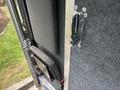 A 2018 Ford Econoline showing the interior door handle and a black fabric storage area with metal fasteners