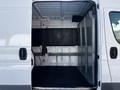 A 2017 RAM Promaster van with the side door open showcasing an empty and spacious cargo area with gray walls and a black floor