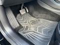 A close-up view of the floor mat and pedals inside a 2019 Tesla Model 3