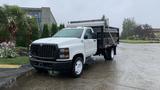 A white 2021 International CV515 truck with a black flatbed parked on a wet surface