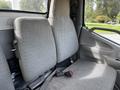 Interior view of a 2004 Toyota Toyoace showing two gray fabric-covered seats with seatbelts and a simple dashboard design in the foreground